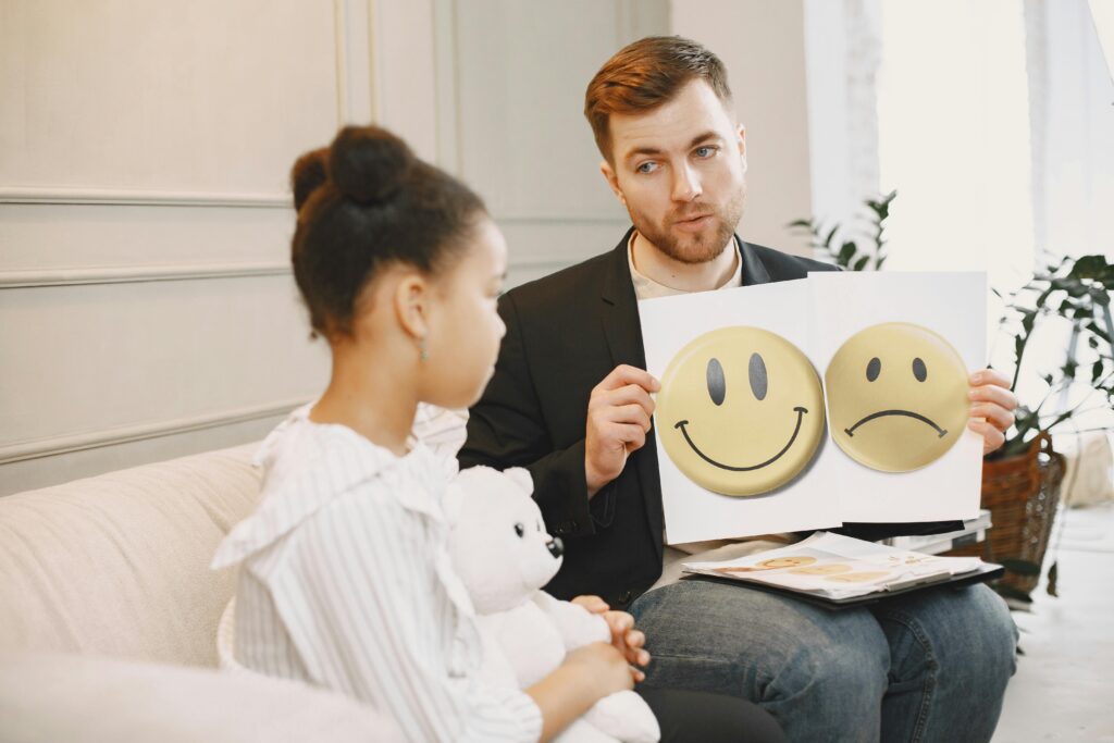 A child and therapist engaging in a therapy session, with the parent present to provide emotional support and encouragement.