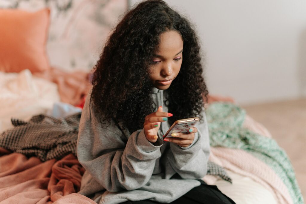 A teen looking stressed while browsing social media, illustrating the mental health risks associated with excessive social media exposure, such as anxiety and low self-esteem.
