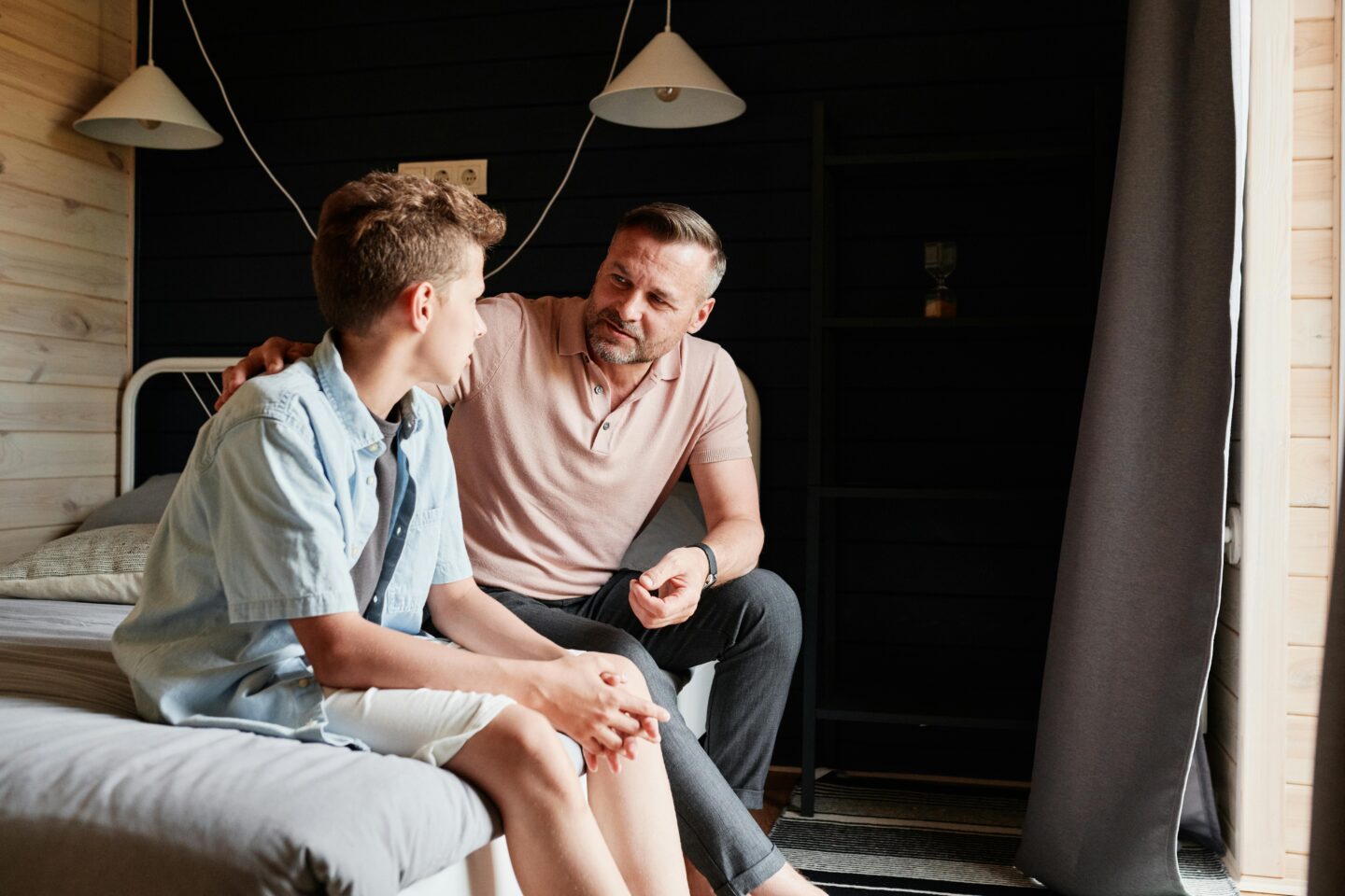 A parent and teen having a serious conversation about social media use, highlighting the importance of open communication to protect youth mental health.