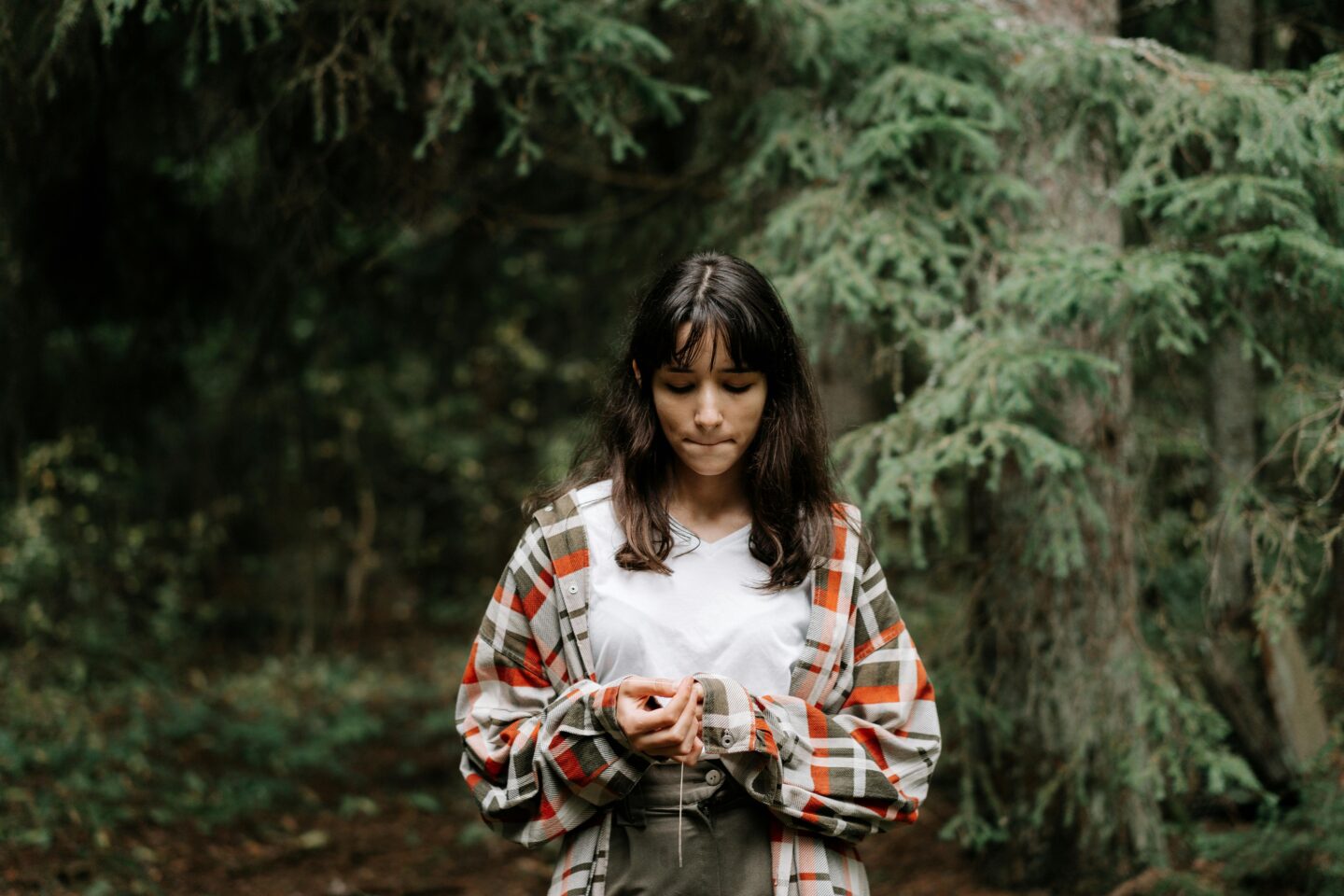 A teen sitting quietly outdoors, eyes closed, practicing mindfulness to reduce stress and anxiety.