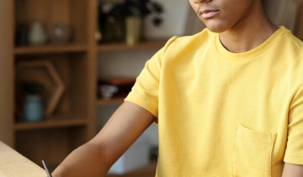 A teen quietly working through a DBT skills workbook to manage emotions and reduce stress.