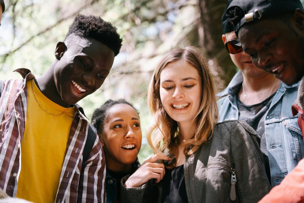 A diverse group of teenagers smiling and spending time together, representing healthy teen friendships.