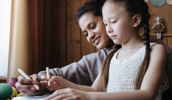 A child and parent writing down in a planner preparing for back-to-school.
