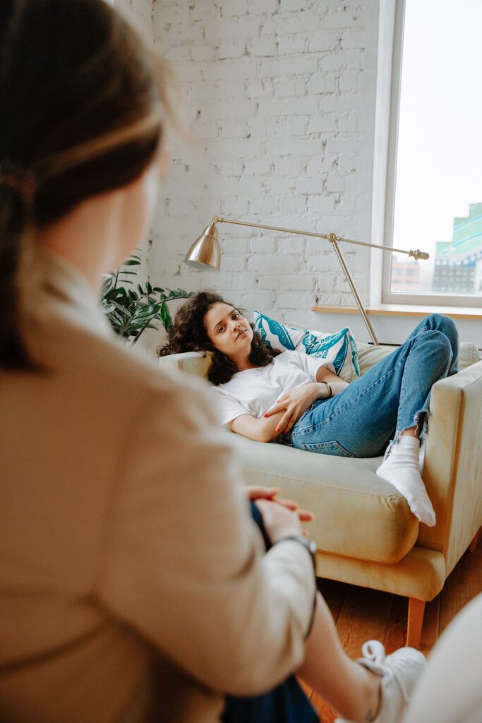A teenager talking to a therapist in a welcoming, comfortable office setting.